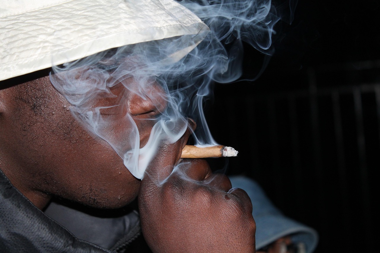 Man in hat smokes fat joint (photo by Audrey Steenhaut on Pixabay)