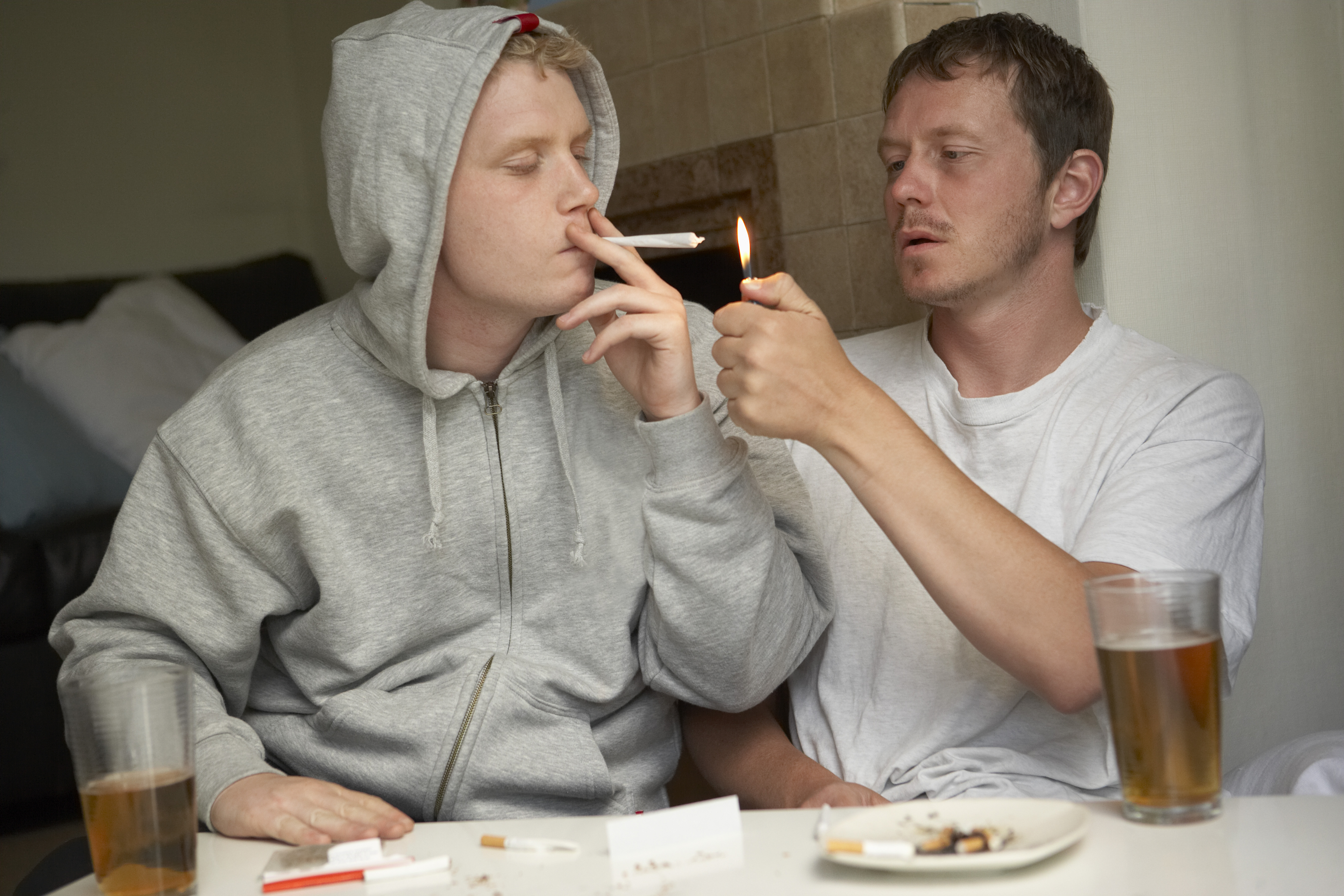 Friends share beer and joint (photo by BananaStock on FreeImages)